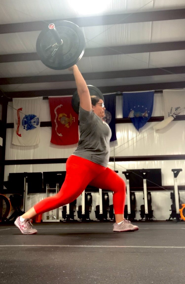 Kelly Fucheck presses 125 pounds overhead during a barbell clinic. 